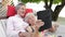 Senior Couple Relaxing In Beach Hammock Using Digital Tablet