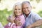 Senior Couple Relaxing In Sunny Summer Field