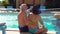 Senior couple relaxing and talking by swimming pool in hotel. People enjoying vacation. All inclusive.