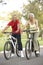 Senior Couple Riding Bikes In Park