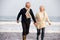 Senior Couple Running Along Winter Beach