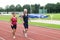 Senior Couple Running On A Track