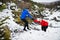 A senior couple running uphill in snowy winter nature.