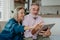 Senior couple scrolling tablet in their livingroom.