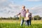 Senior couple with shovel and carrots on farm