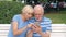 Senior couple sit on bench in park look for direction via online app with city map on mobile phone