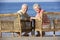 Senior Couple Sitting In Chairs Relaxing On Beach