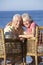 Senior Couple Sitting In Chairs Relaxing On Beach