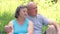 Senior couple sitting on grass together relaxing