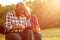 Senior couple sitting on a park bench looking at tablet