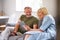 Senior Couple Sitting On Sofa In Lounge At Home Using Digital Tablet Together