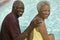 Senior Couple sitting by swimming pool portrait.