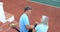 Senior couple sitting on tennis court stairs 4k