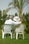 Senior couple sitting at tropic hotel garden