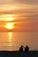 Senior couple sitting and watching a tropical sunset