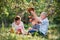 A senior couple with small grandson in apple orchard, having fun.