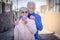 Senior couple smiling outdoors taking off protective masks against coronavirus contagion. Two pensioners already vaccinated