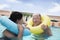 Senior couple smiling and relaxing in the pool with inflatable tubes