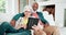 Senior couple on sofa with tablet, smile and relax with love, interracial marriage and bonding in home. Social media