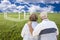 Senior Couple Standing in Grass Field Looking at Ghosted House