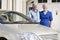 Senior couple standing to new car