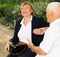 Senior couple talking on bench in park