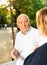 Senior couple talking on bench in park