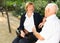 Senior couple talking on bench in park