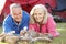 Senior Couple Toasting Marshmallows Over Fire Camping Holiday