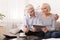 Senior couple using digital tablet in living room