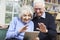 Senior Couple Using Digital Tablet For Video Call With Family