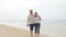 Senior Couple Walking Along Misty Beach