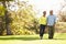 Senior Couple Walking Through Autumn Woodland