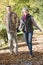 Senior couple walking through autumn woods