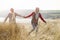 Senior Couple Walking Through Sand Dunes On Winter Beach