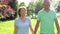 Senior Couple Walking Through Summer Field Together