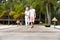 Senior Couple Walking On Wooden Jetty