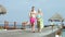 Senior Couple Walking On Wooden Jetty