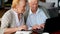 Senior couple websurfing on internet with laptop. Happy elderly man and woman using computer