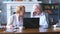 Senior couple websurfing on internet with laptop. Happy elderly man and woman using computer