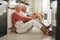 Senior couple, wine and laughing on kitchen floor thinking happy memories and talking about love during a celebration of