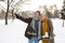 Senior couple in winter nature with ice skates going to rink.