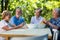 Senior couples removing seeds of apricot fruits in garden