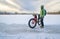 Senior cyclist is riding a fat bike in winter