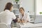 Senior doctor checking patient blood pressure at hospital. Young woman consulting cardiologist at clinic