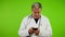 Senior doctor with fingers fast texting message chatting on his smartphone.