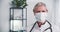 Senior doctor posing at work. Happy 60 grey haired physician woman wears face mask, white lab coat and stethoscope.