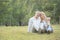 Senior elder caucasian couple sitting on ground together in park in Autumn. Wife resting head on husband head and put hands on man