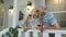 Senior elderly caucasian couple drinking wine, looking ahead, making a kiss in porch at home