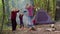 Senior elderly grandmother grandfather with granddaughter dancing celebrating over campfire in wood.